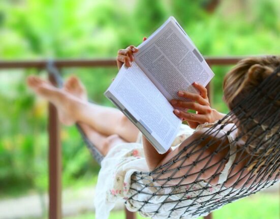 девушка читает книгу в гамаке