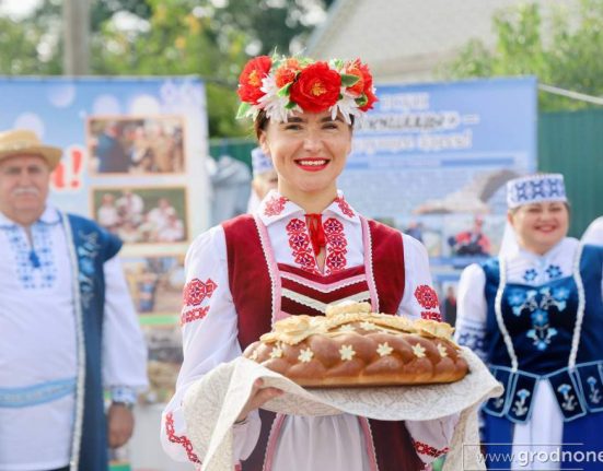 Девушка в национальном белорусском костюме держит каравай